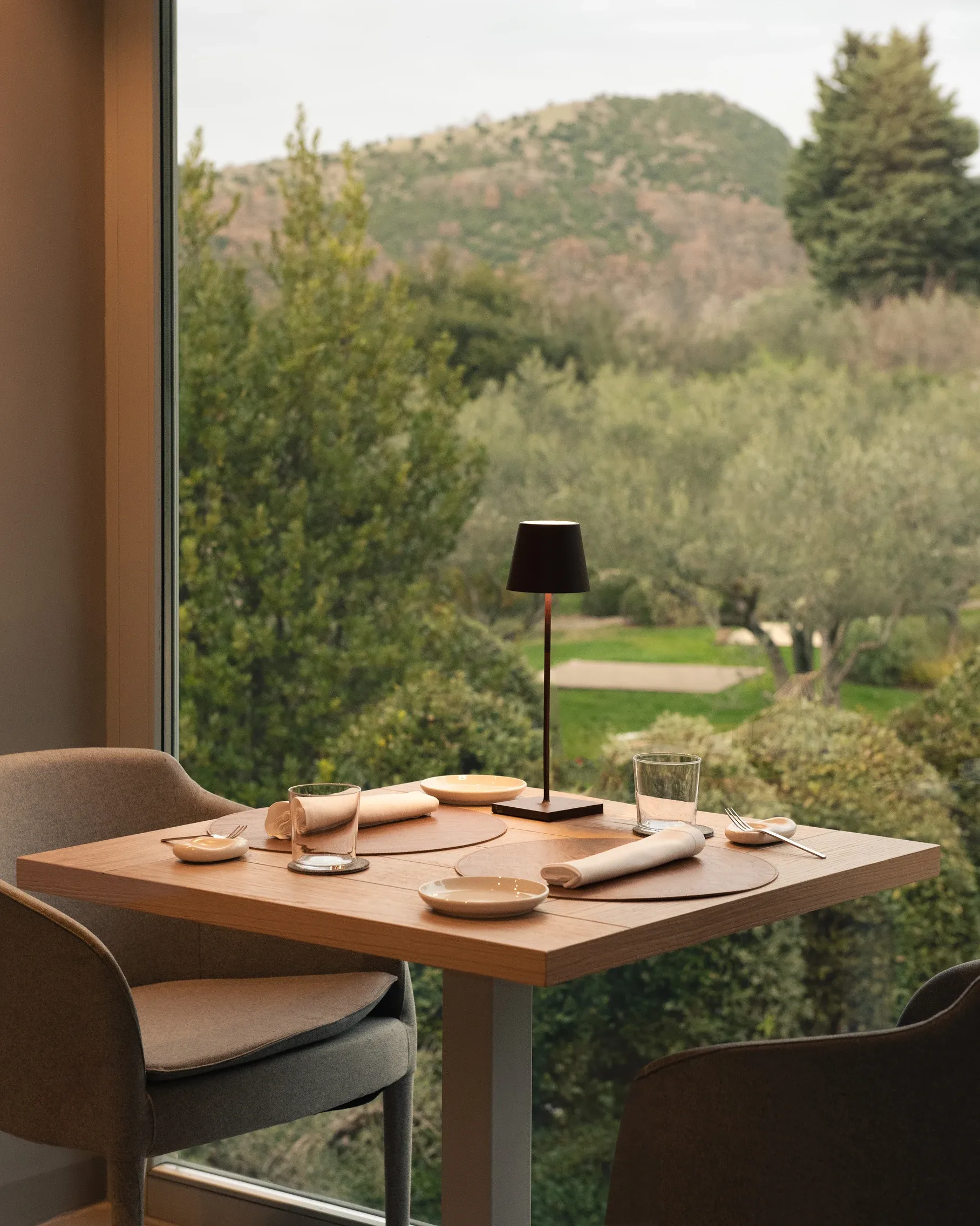 Two-top dining table with view of green hills
