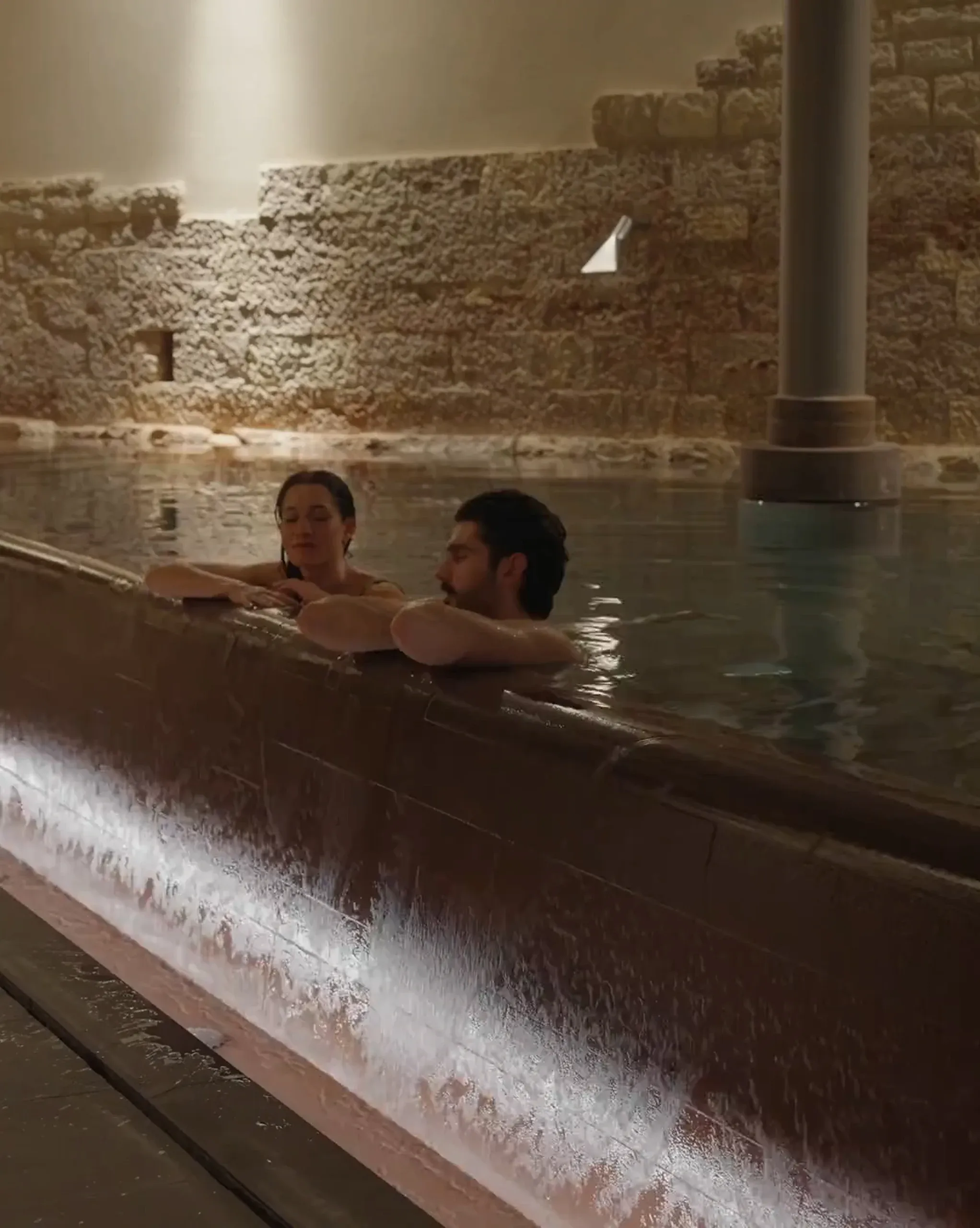 Spa Romana with couple at pool edge and light strip