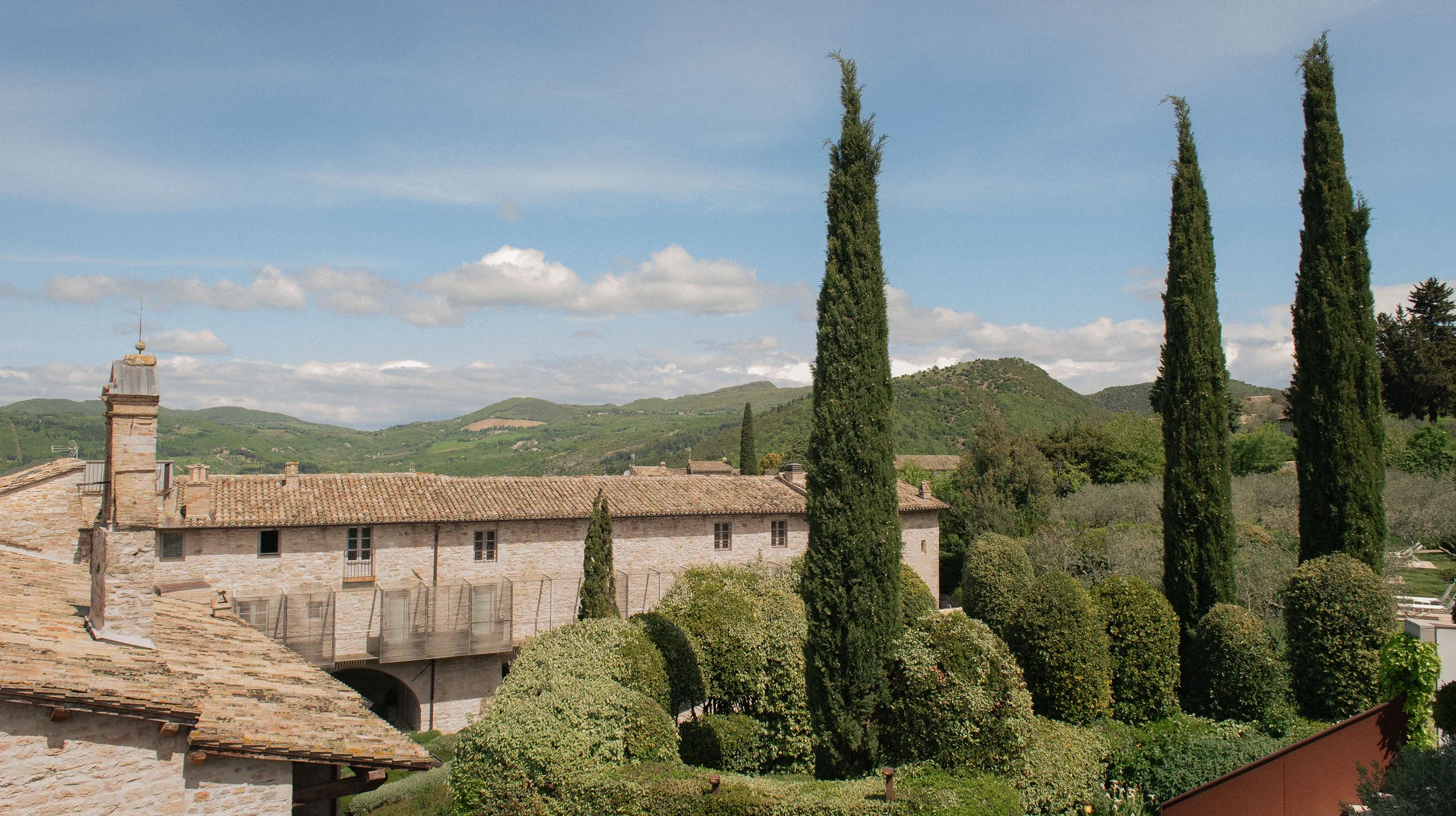 Tile rooftops with cypress trees and Umbrian hills